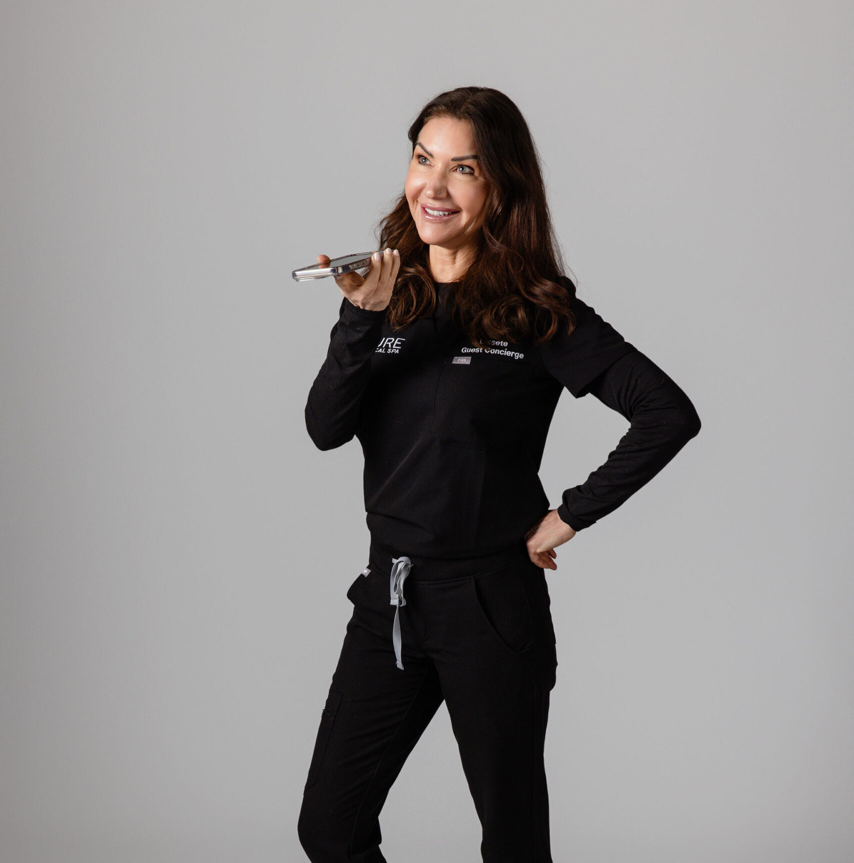 Lissete, Guest Concierge Pure Medical Spa Sun Valley with her cell phone